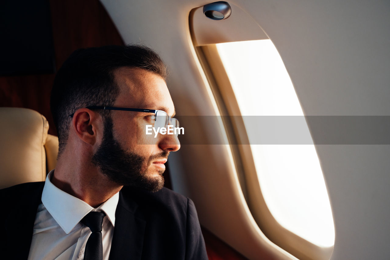 Businessman looking through airplane window