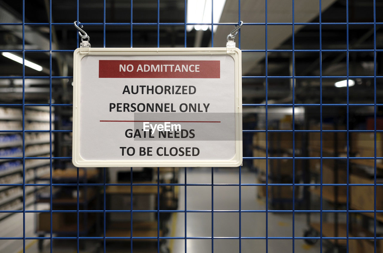 No admittance sign at a closed gate in a warehouse