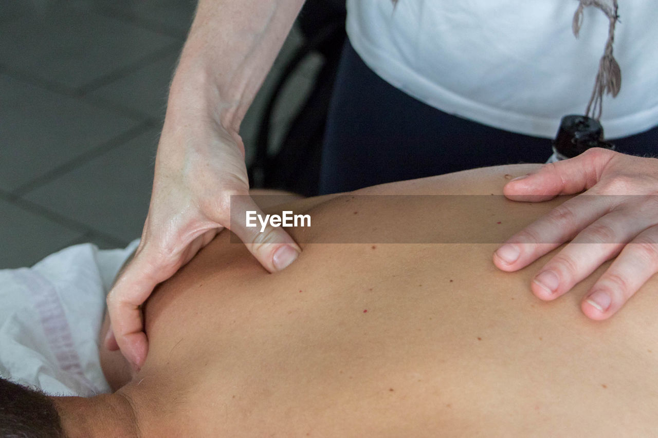 Midsection of physical therapist giving massage to patient