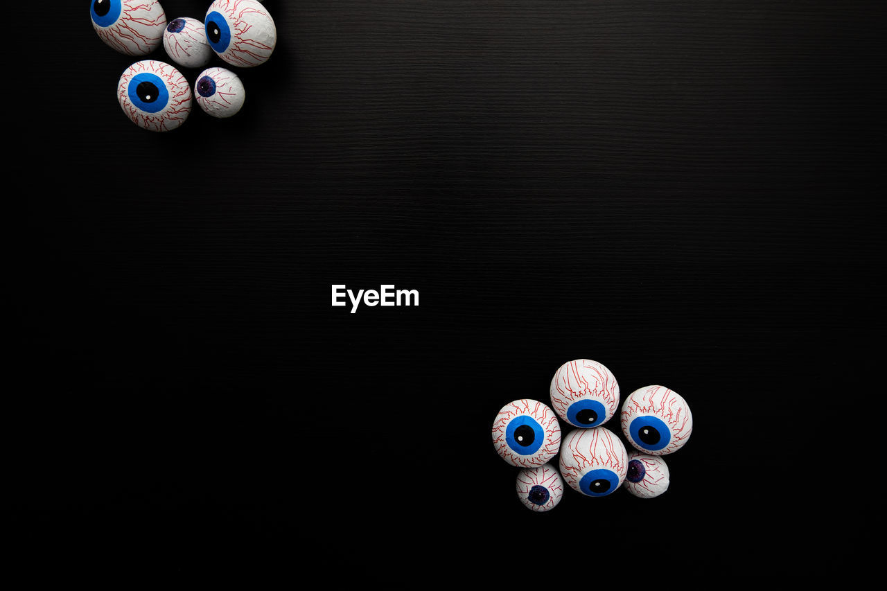 Funny halloween treat - candy eyeballs on dark background. copy space