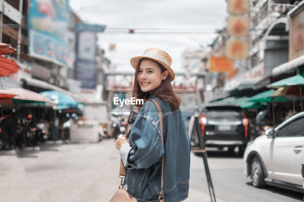 PORTRAIT OF WOMAN STANDING IN CITY