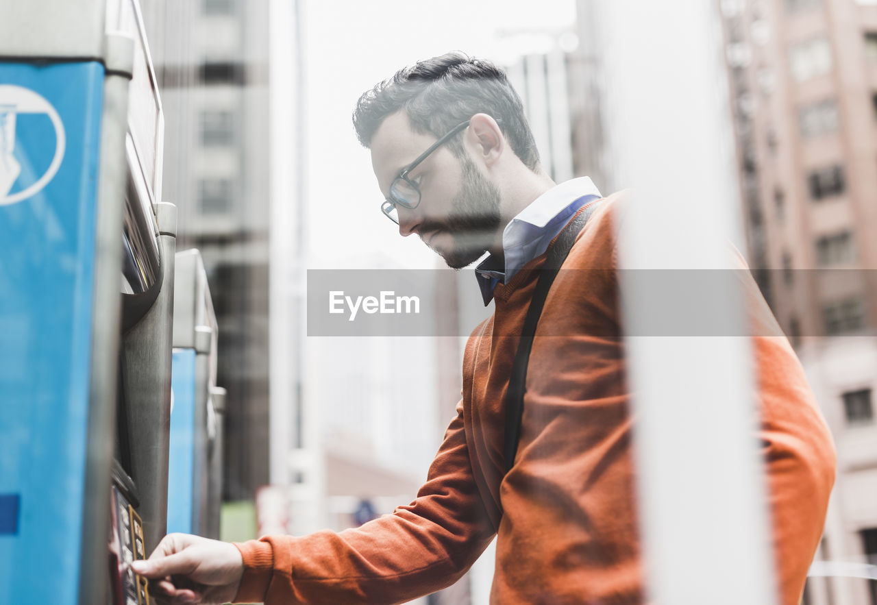 Usa, new york city, businessman using atm