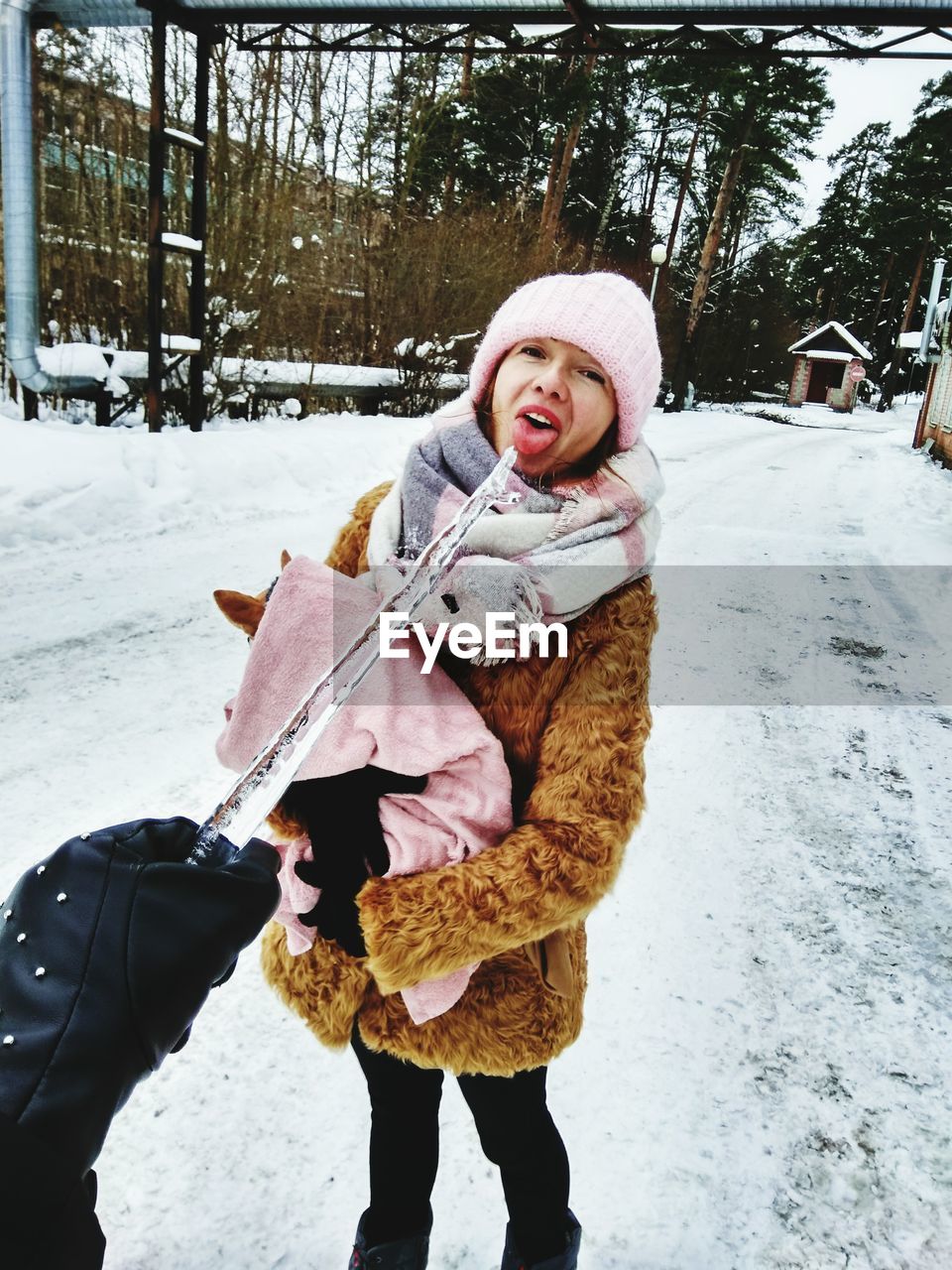 PORTRAIT OF SMILING YOUNG WOMAN HOLDING SNOW