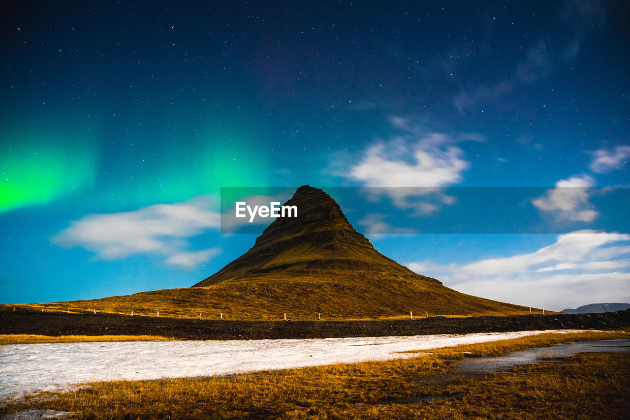Scenic view of kirkjufell mountain against night sky with aurora borealis