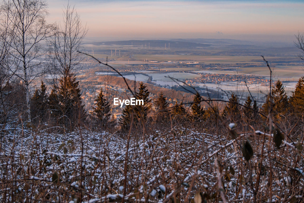 Scenic view of frozen field against sky during winter