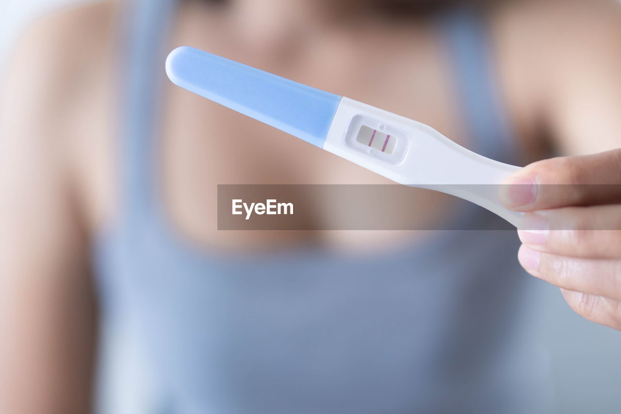 Close-up of woman holding pregnancy test