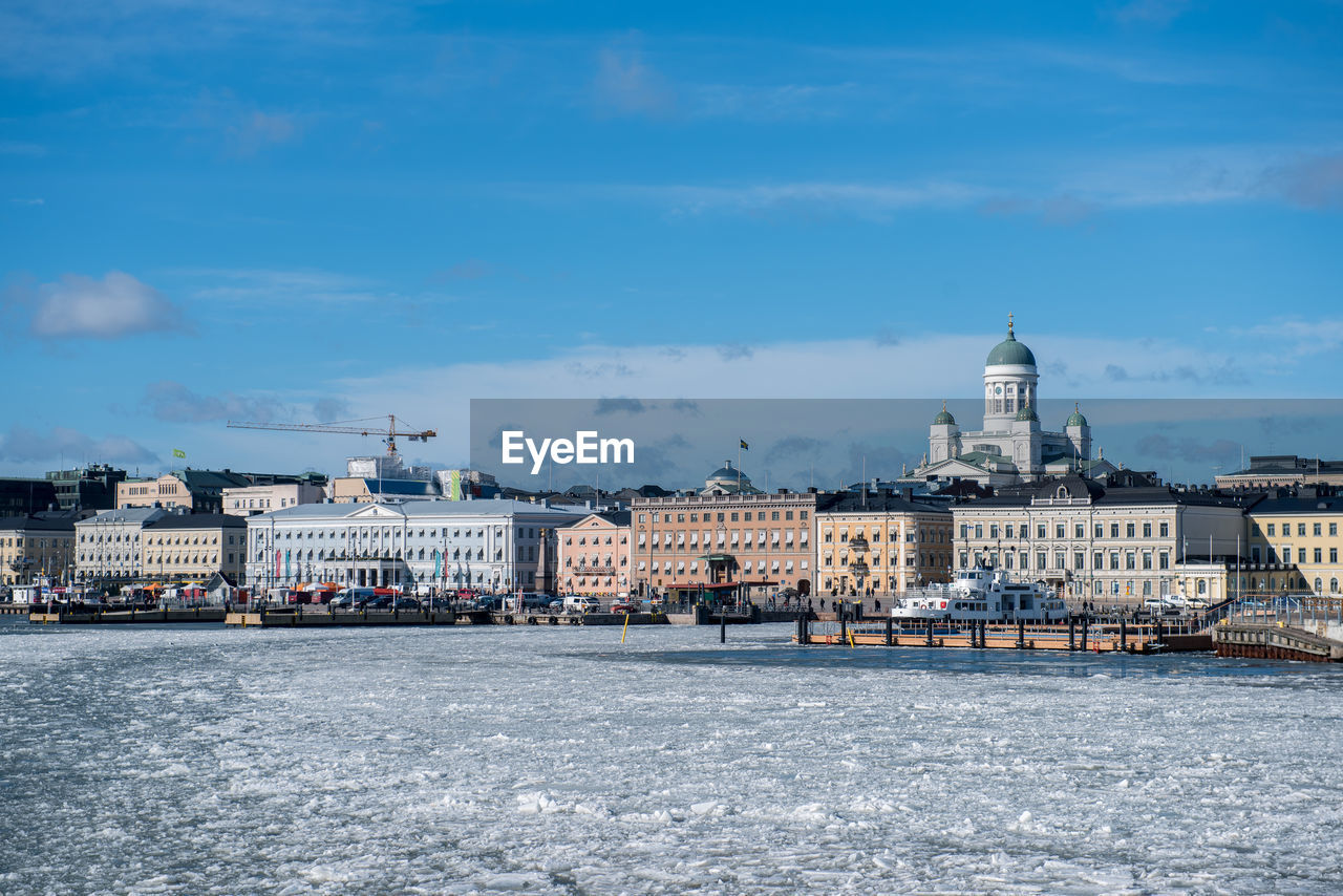 River by cityscape with helsinki cathedral against sky