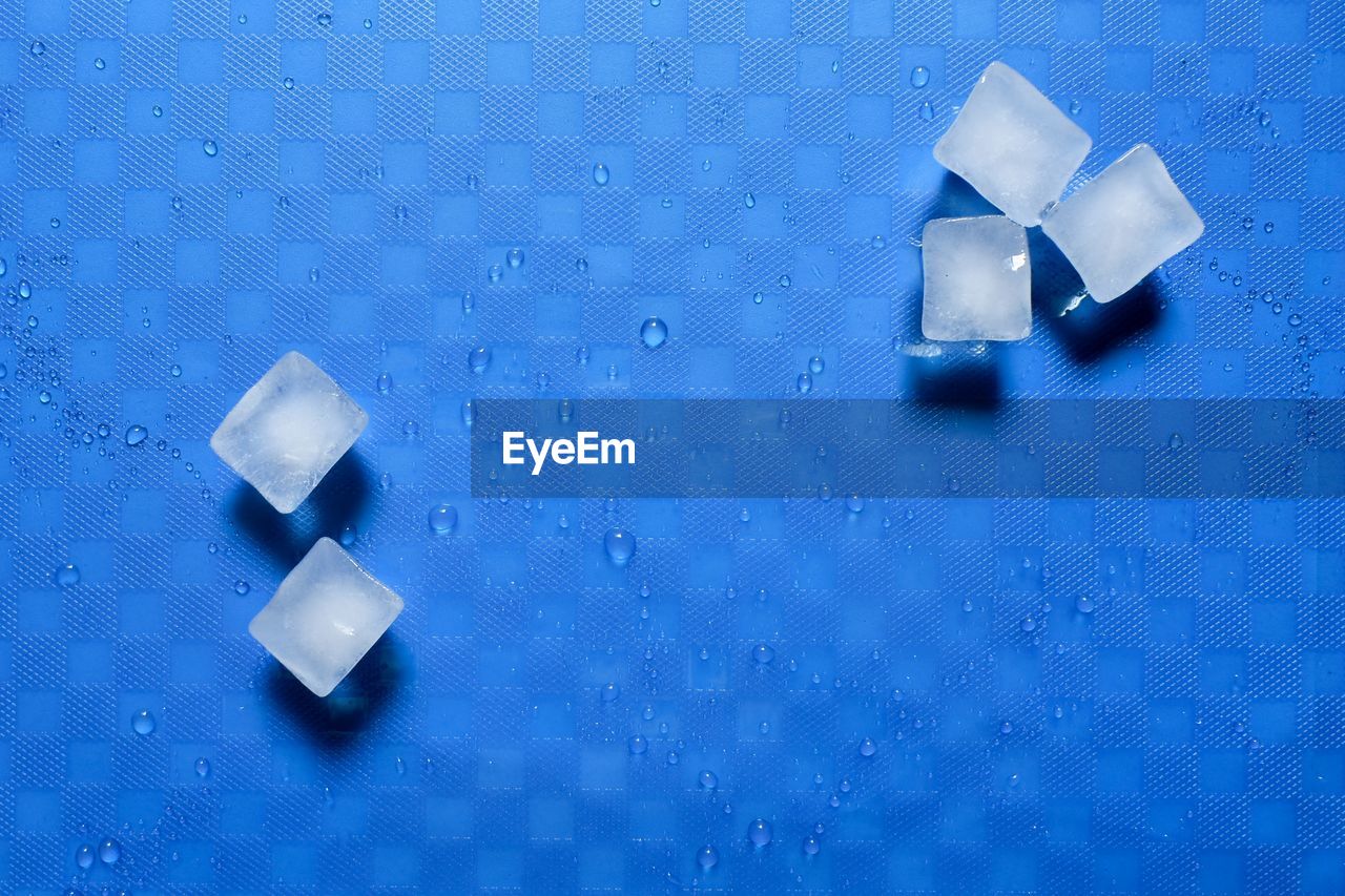 High angle view of dices on blue background