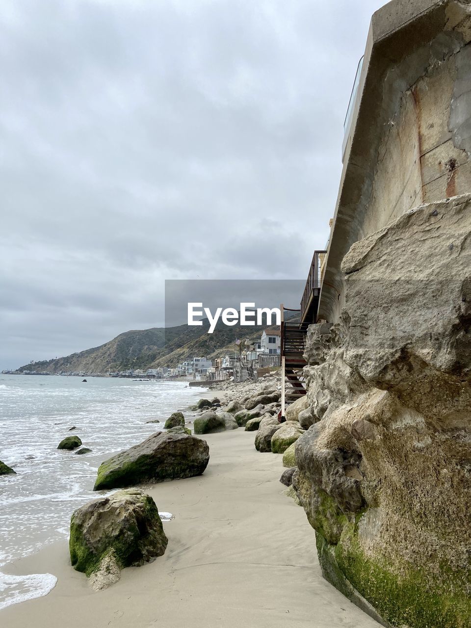Scenic view of sea by buildings against sky