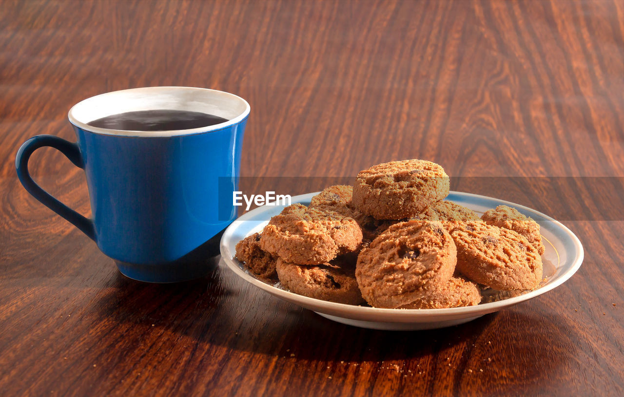 Chocolate chip cookies on a saucer and a cup of coffee