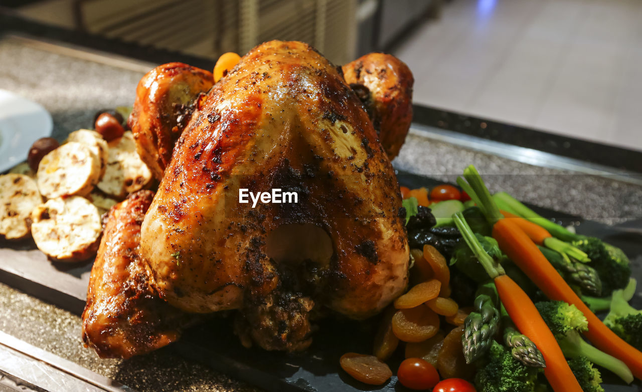 Close-up of roasted chicken on slate