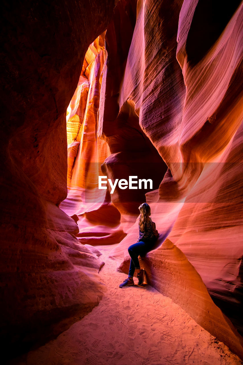 Full length of woman leaning on rock formation at grand canyon