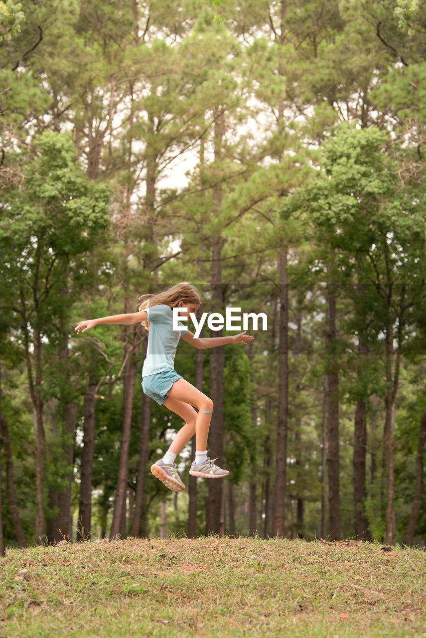 Young girl jumping in a forest