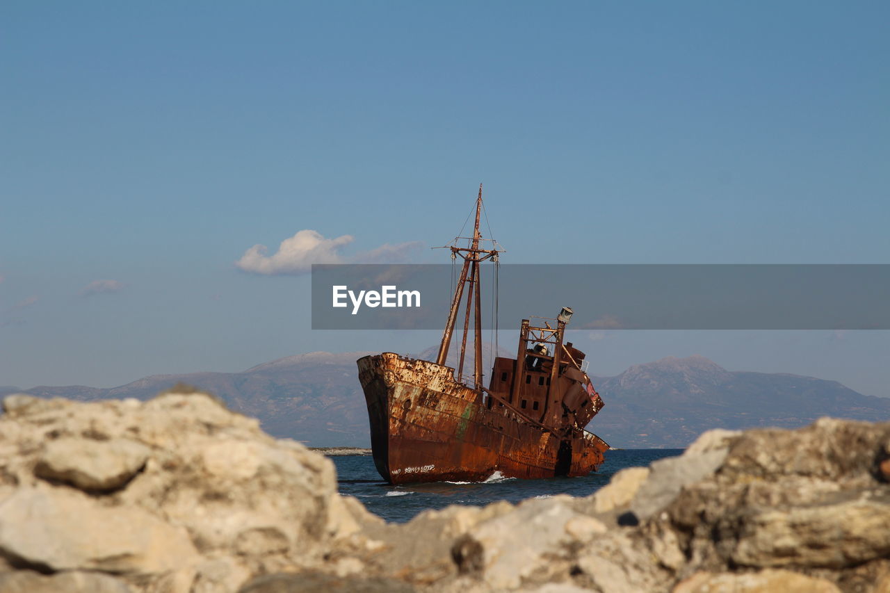 Abandoned boat on shore against sky