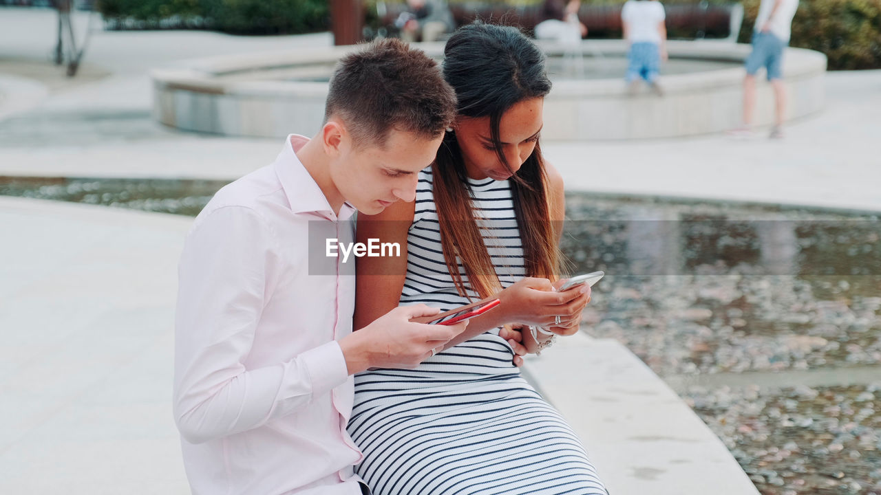 side view of young woman using phone