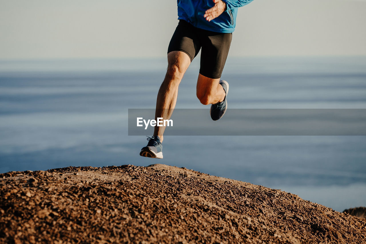 Low section of man running on mountain