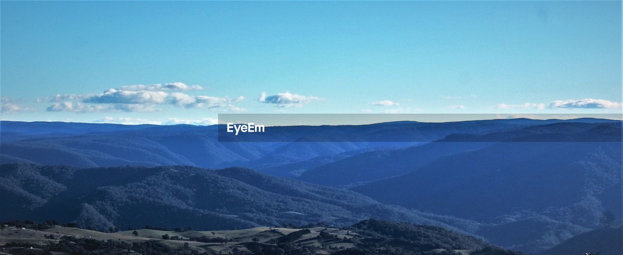 Scenic view of mountains against blue sky
