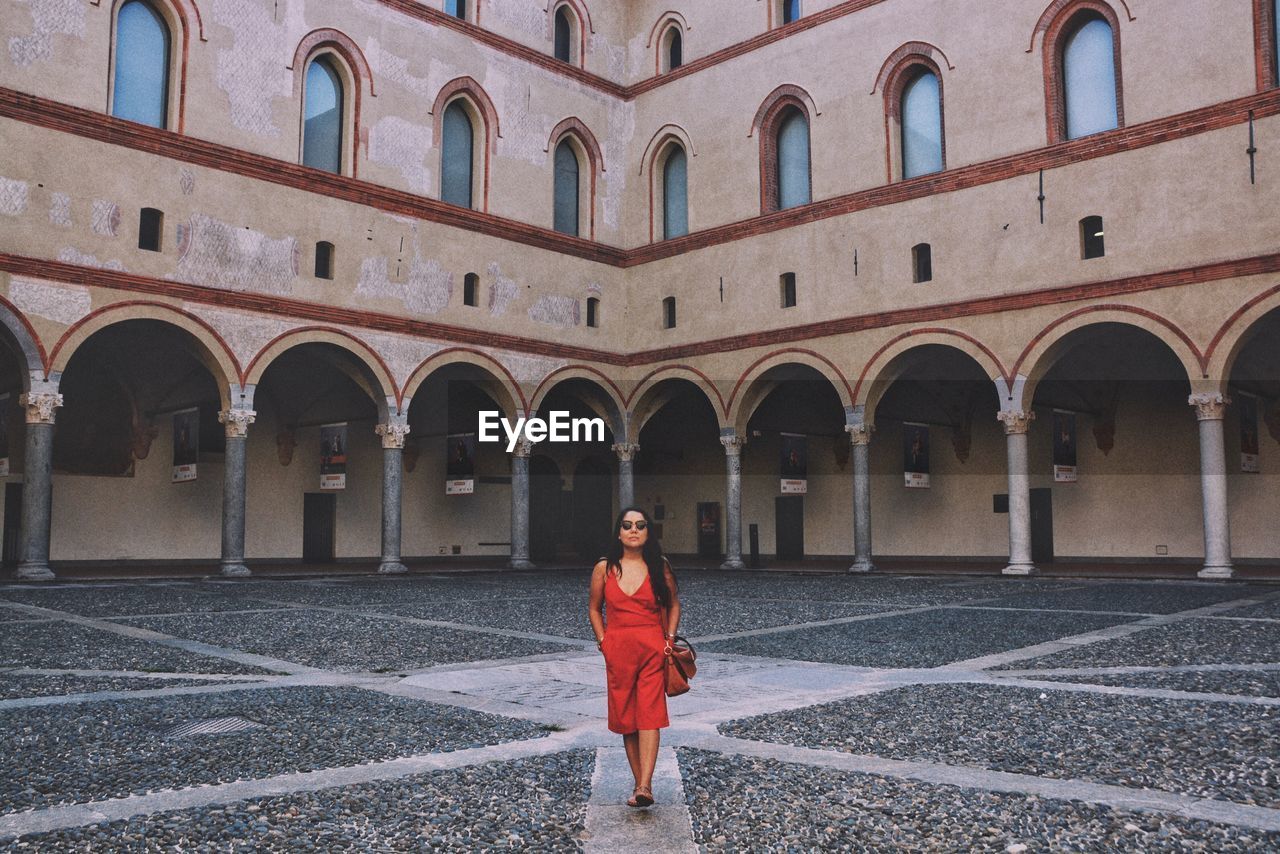 Full length of woman standing against building