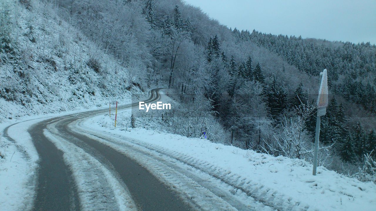 Road amidst snow covered trees