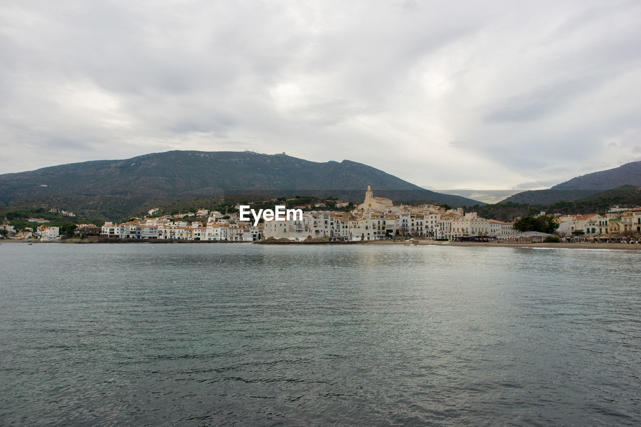 Scenic view of sea by mountains against sky