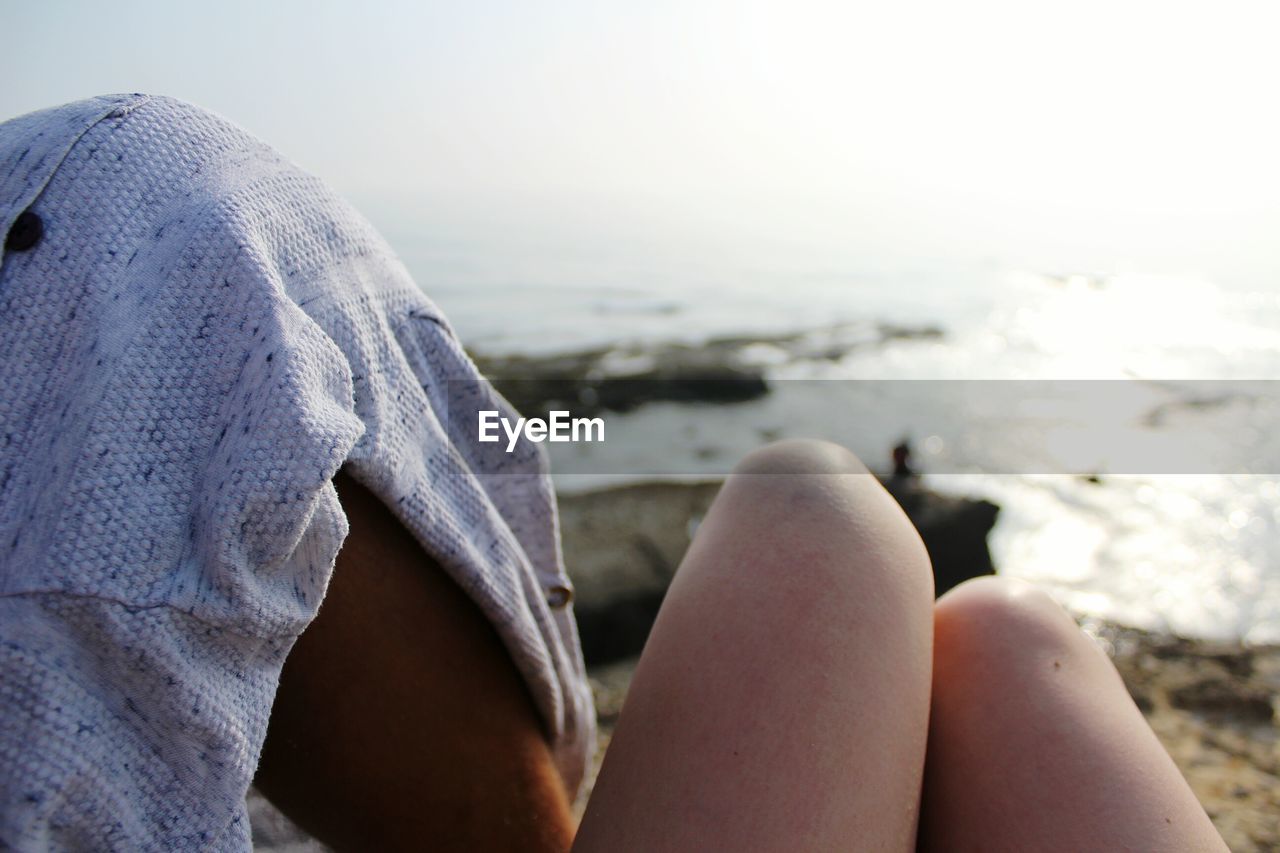 Low section of women relaxing on beach