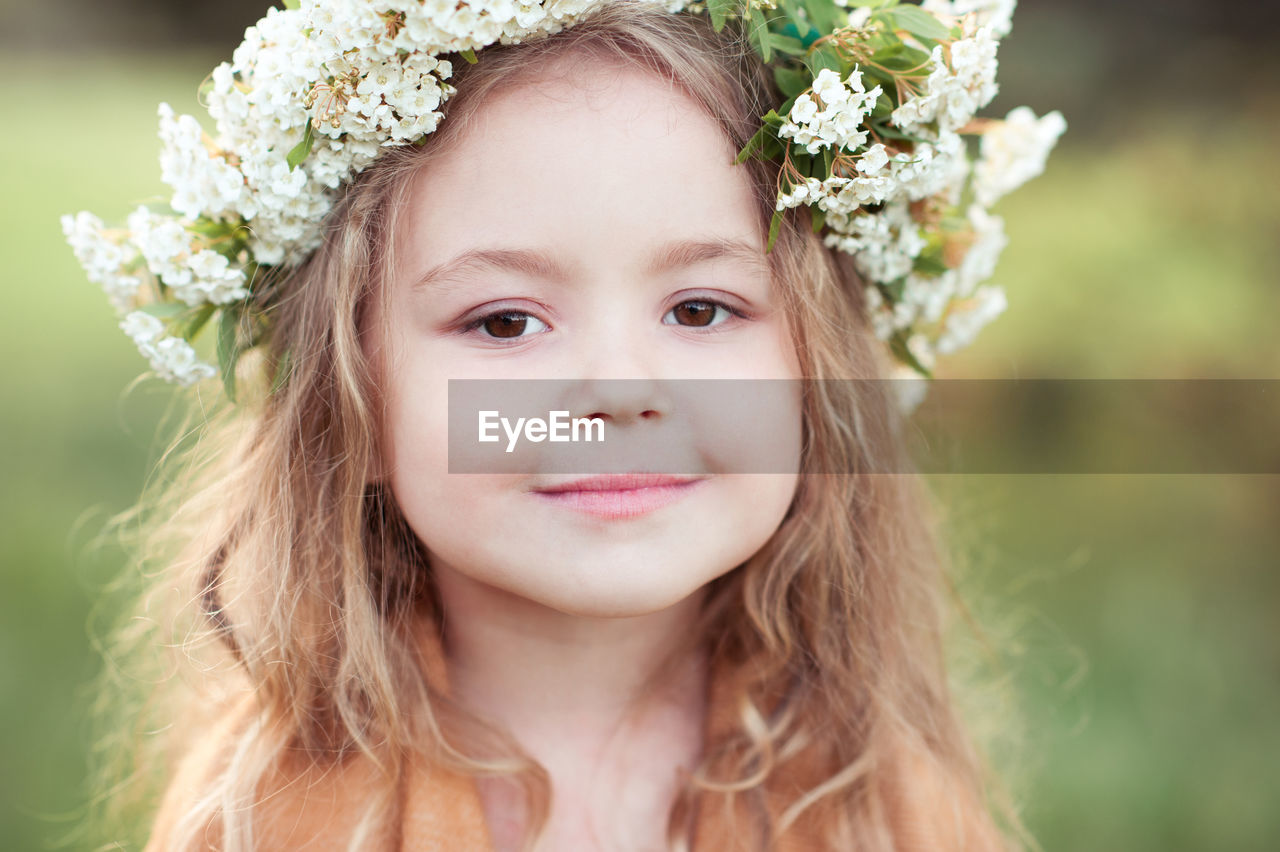 Close-up portrait of cute girl wearing wreath