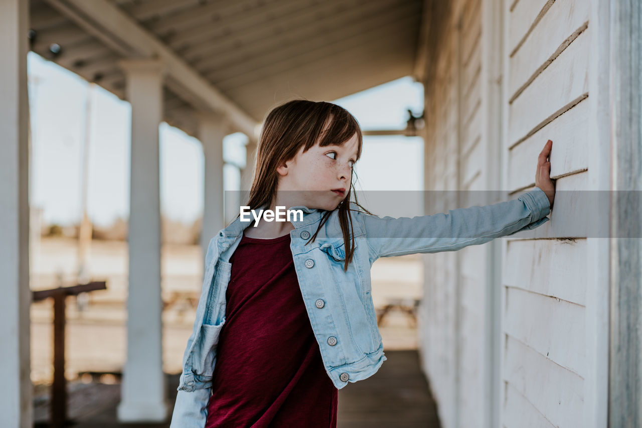 Young girl standing on patio making a silly face