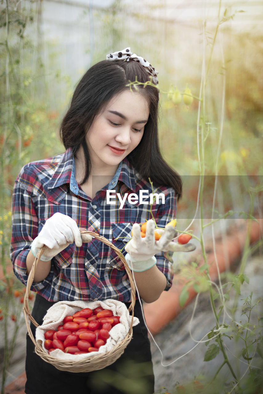 Young woman holding fruits in garden