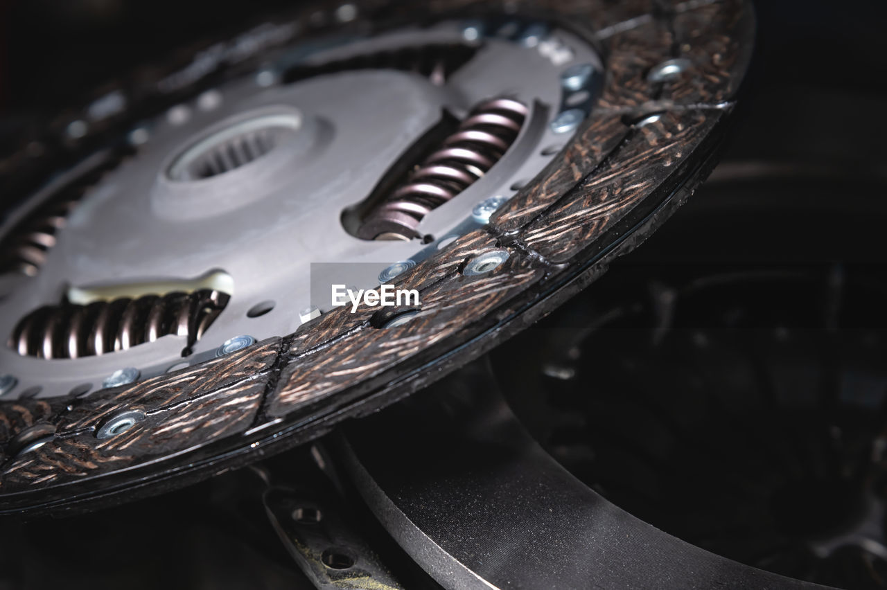 Close-up clutch disc of a car lies on metal parts contrast shot