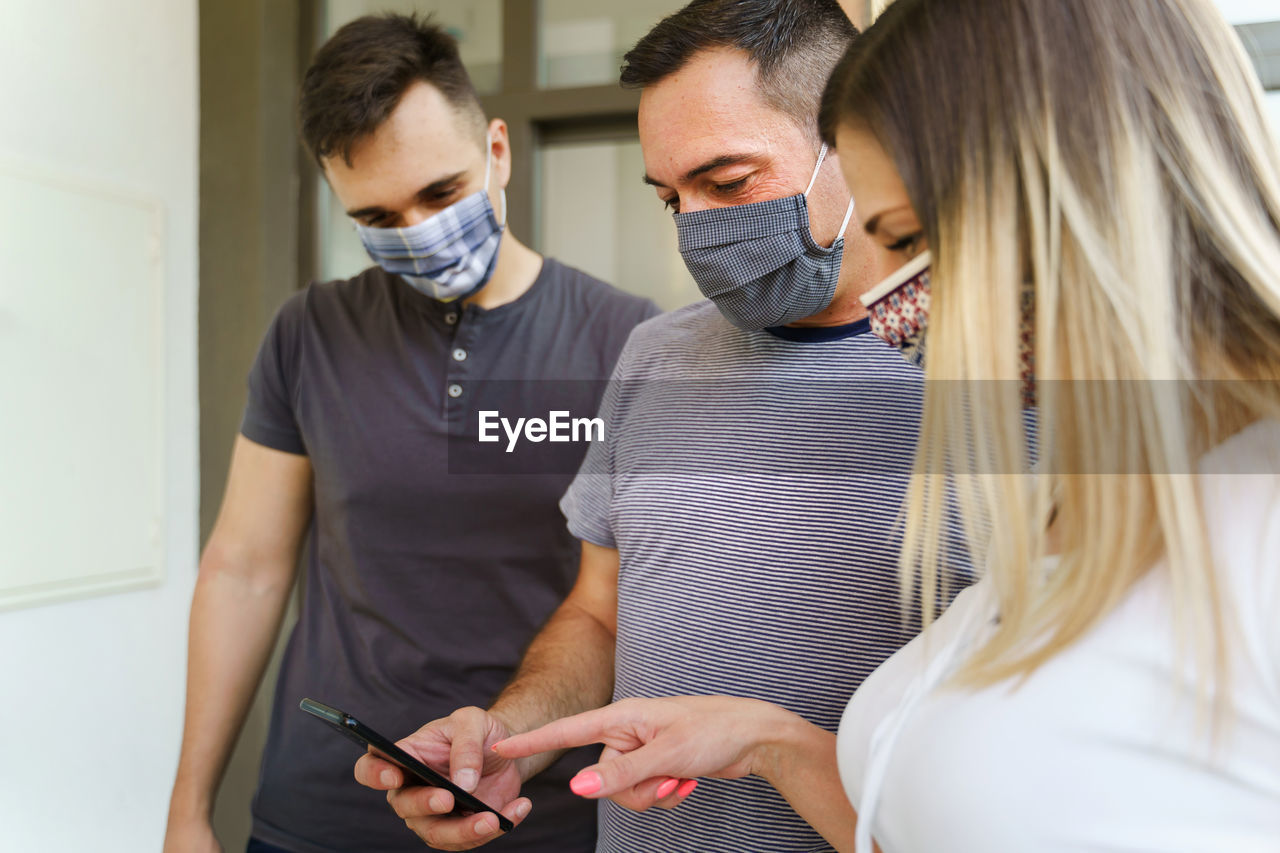 YOUNG COUPLE LOOKING AT WHILE STANDING IN OFFICE