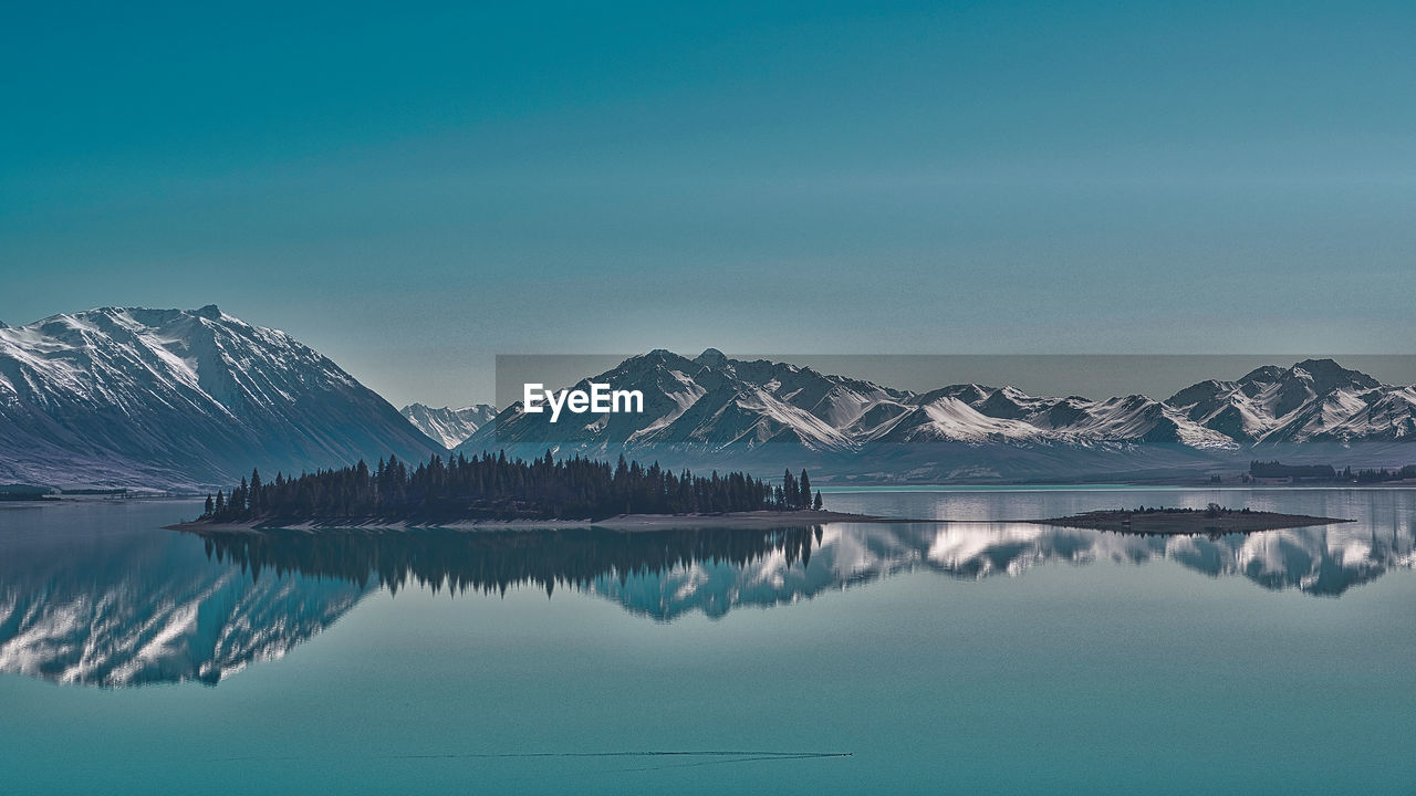 Scenic view of lake and snowcapped mountains against sky