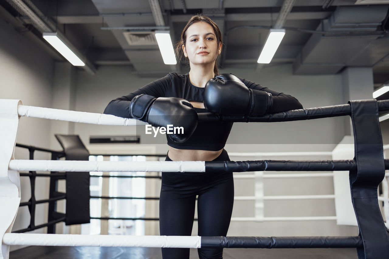 portrait of smiling young woman exercising on gym