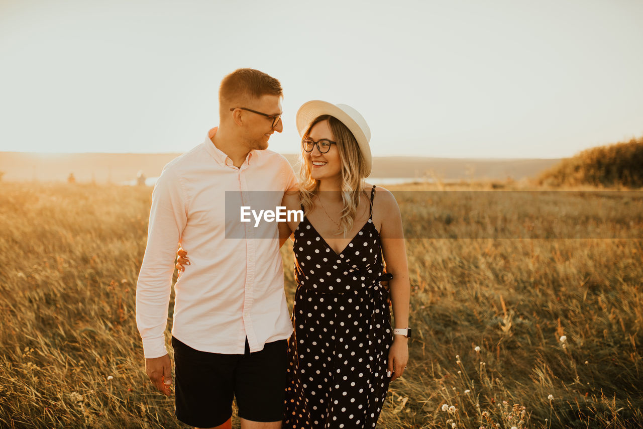 Smiling couple standing on grassy field