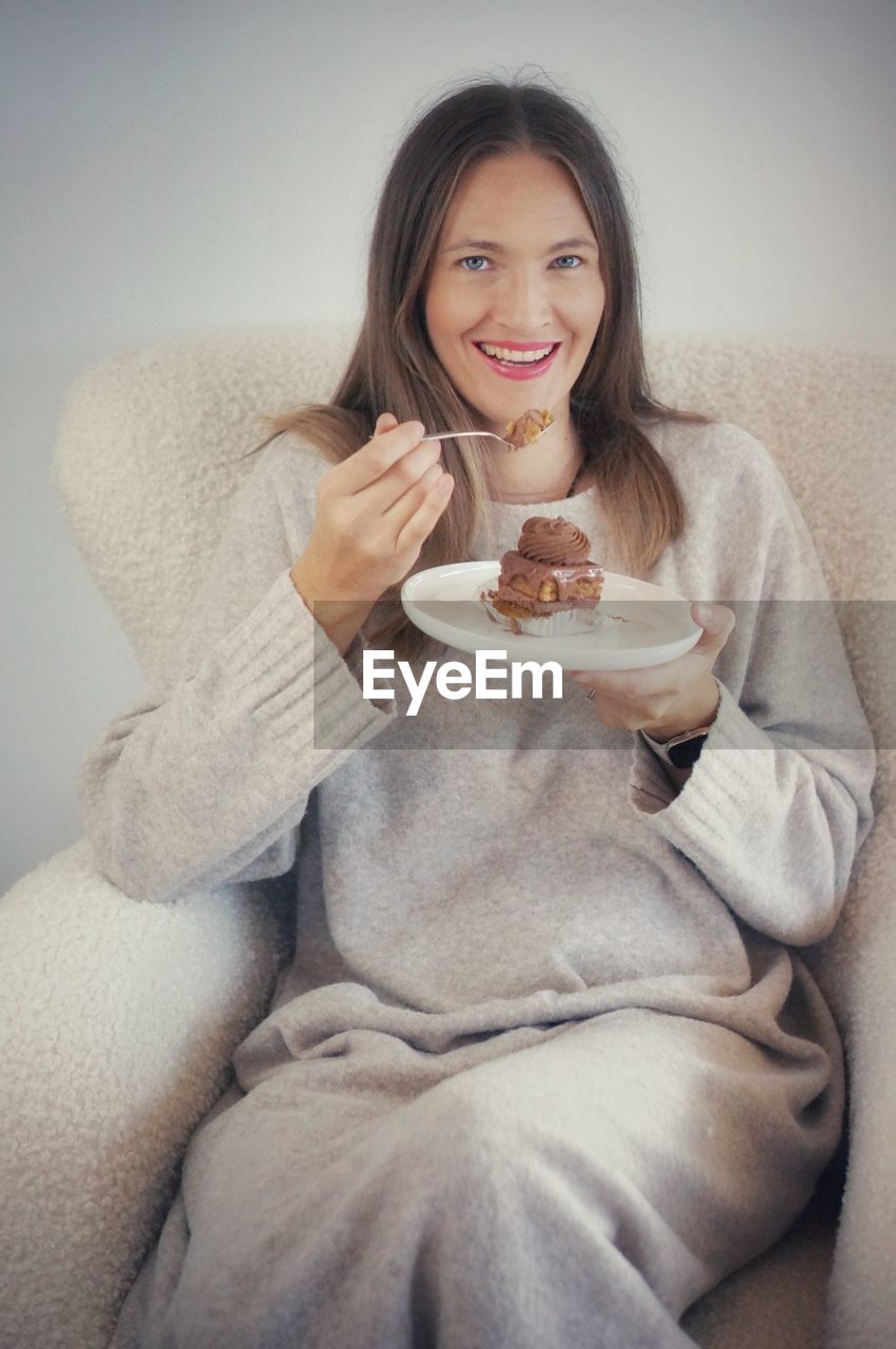 portrait of smiling young woman having breakfast at home