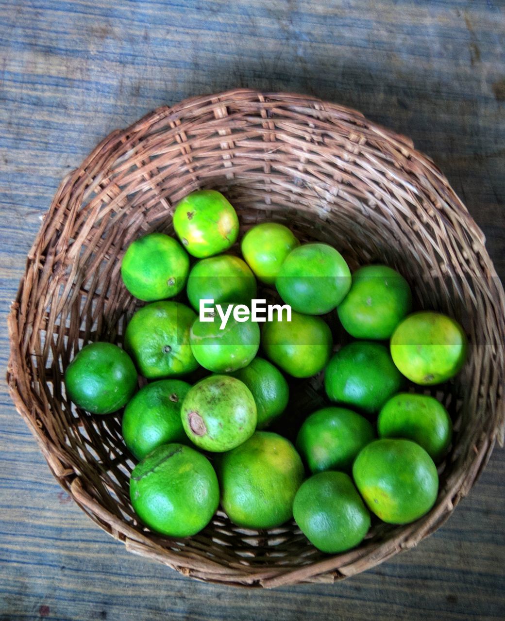 High angle view of green fruits in basket on table