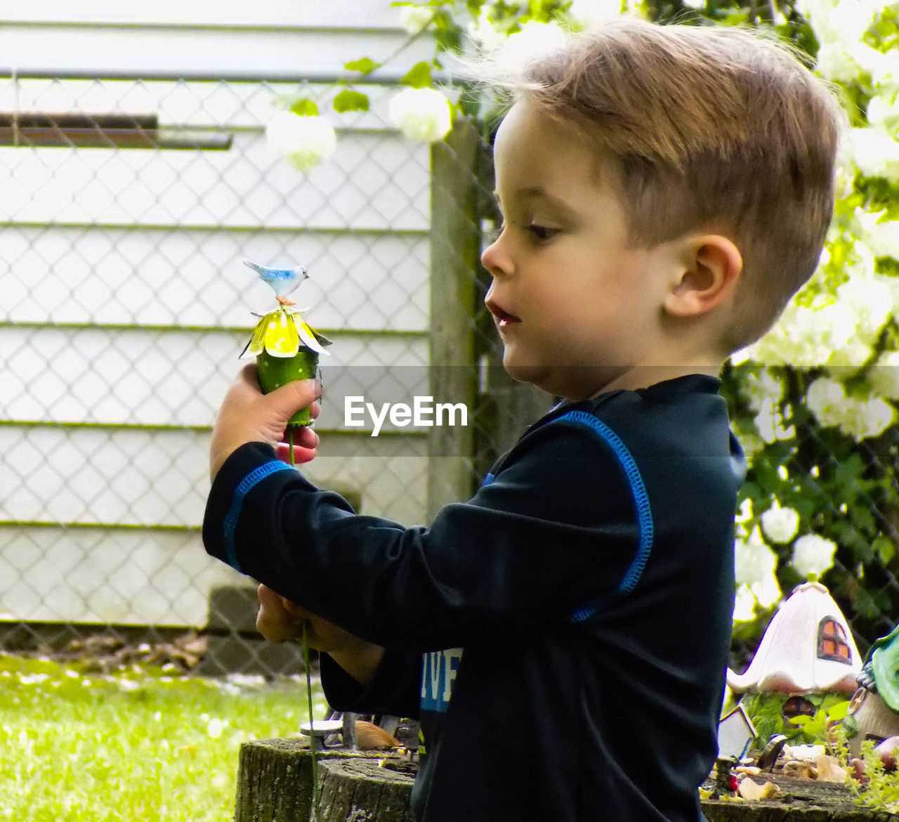 Side view of boy playing with toy at park