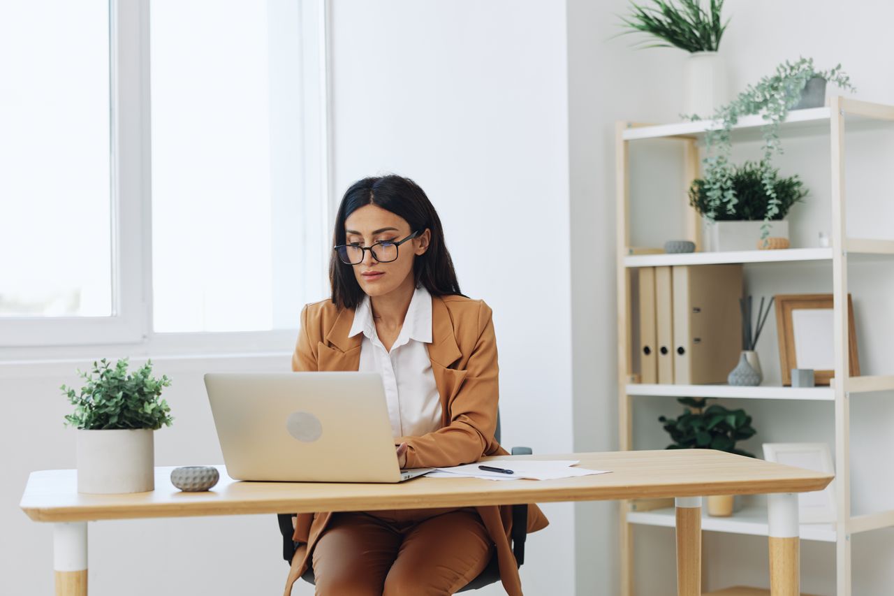 young woman using laptop while sitting on table