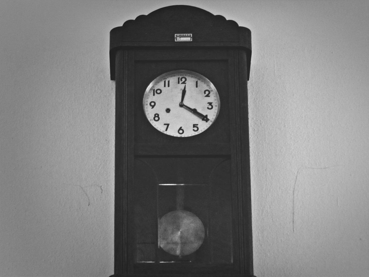 LOW ANGLE VIEW OF CLOCK ON WHITE WALL