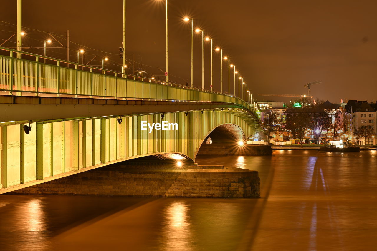 View of bridge over river at night