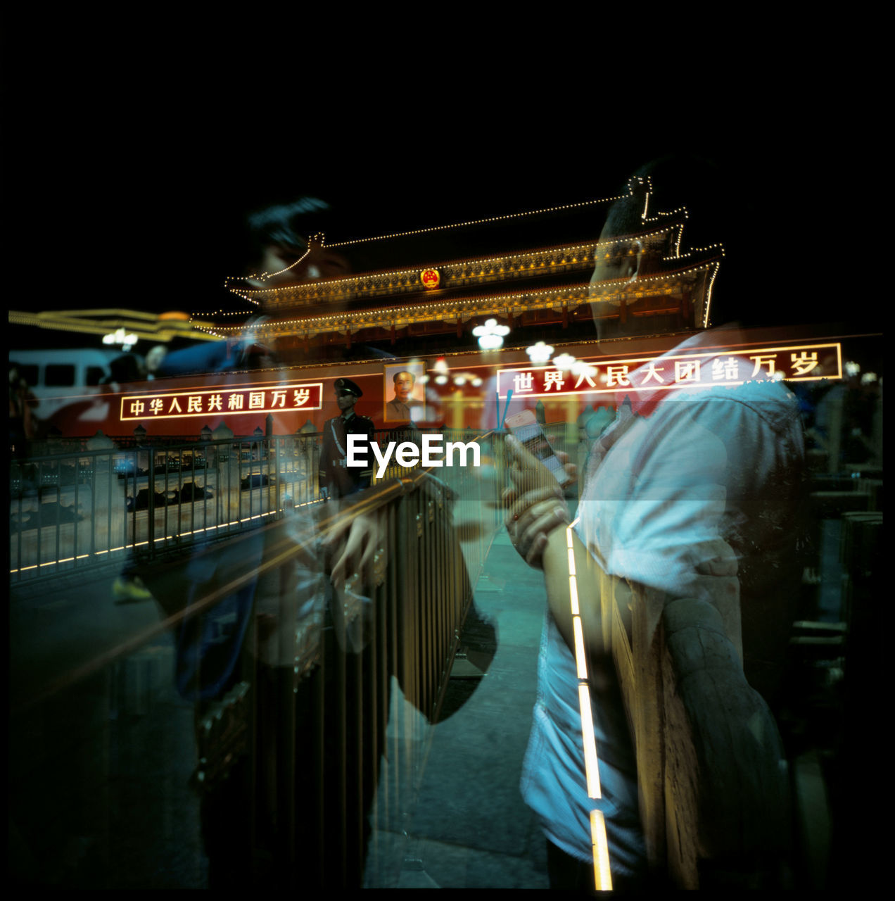 Double exposure of men standing against illuminated forbidden city