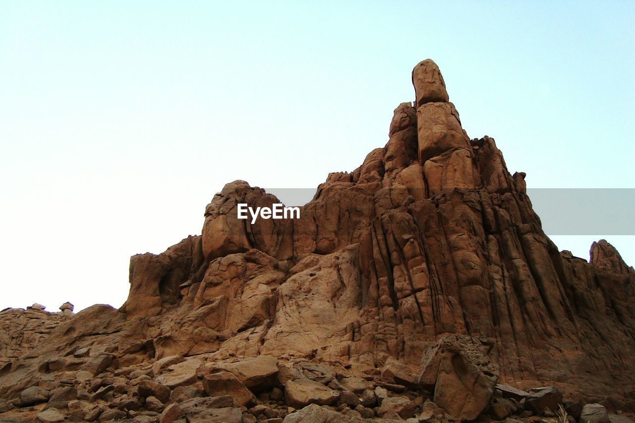 Low angle view of rock formations against clear sky