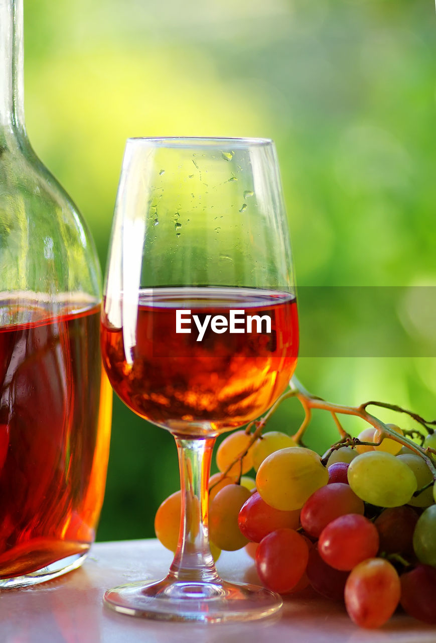 Close-up of red wine and grapes on table