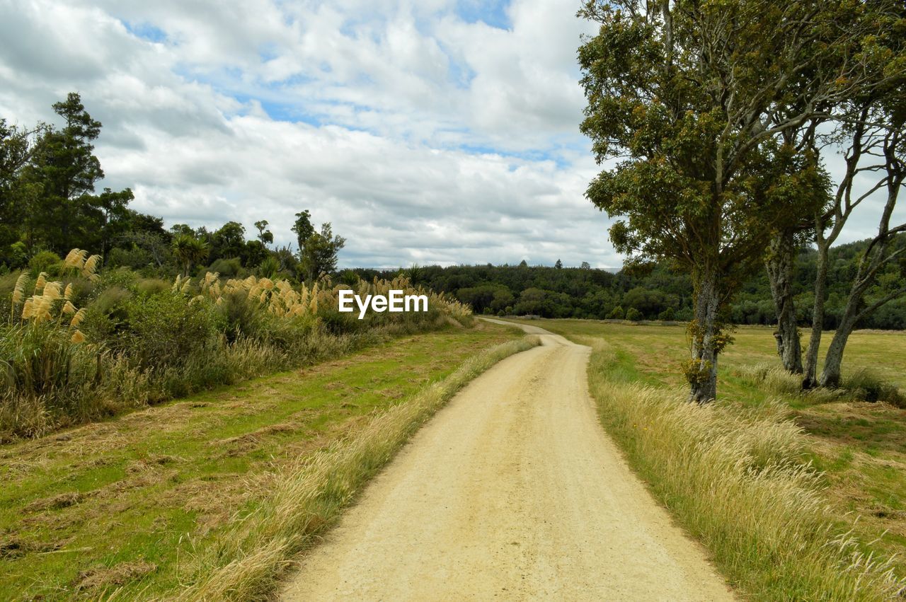 Road amidst field against sky