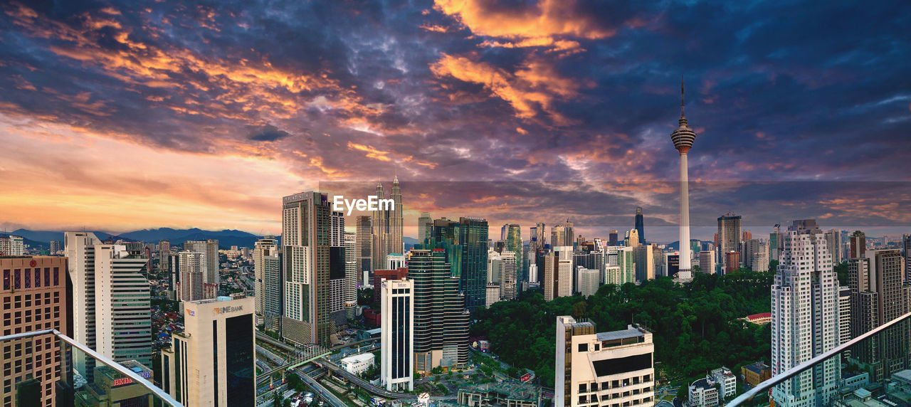 AERIAL VIEW OF MODERN BUILDINGS AGAINST SKY DURING SUNSET