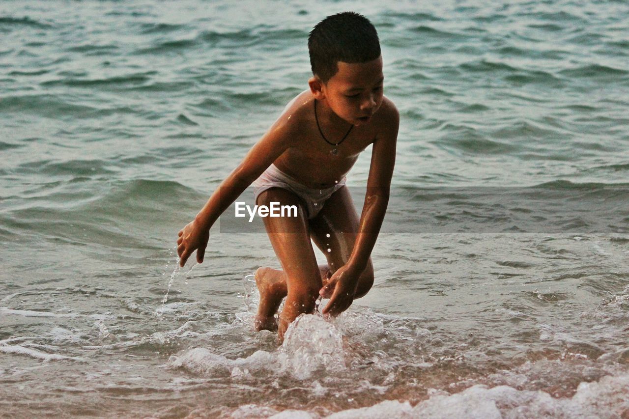 Boy playing in sea waves