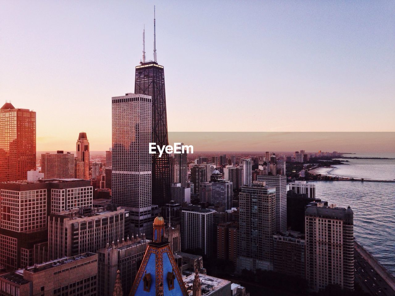 Willis tower by sea against sky in city