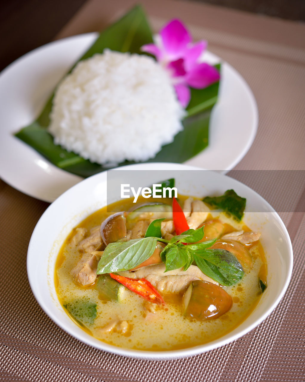 Thai food chicken green curry with rice in wood background