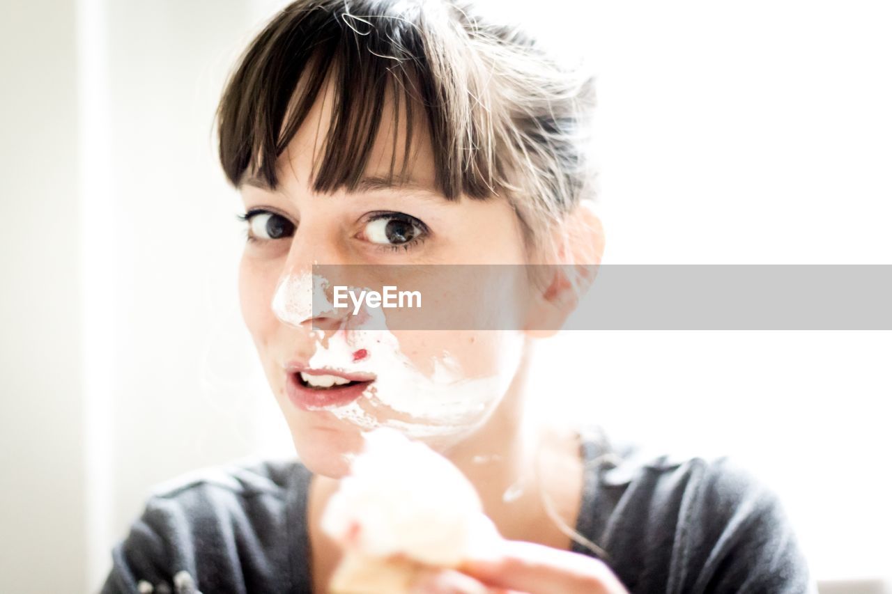 Close-up portrait of woman with messy face at home