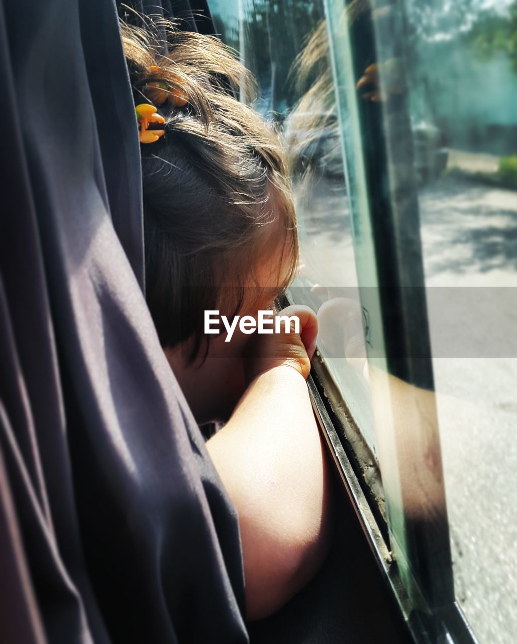 Girl sitting at window in vehicle