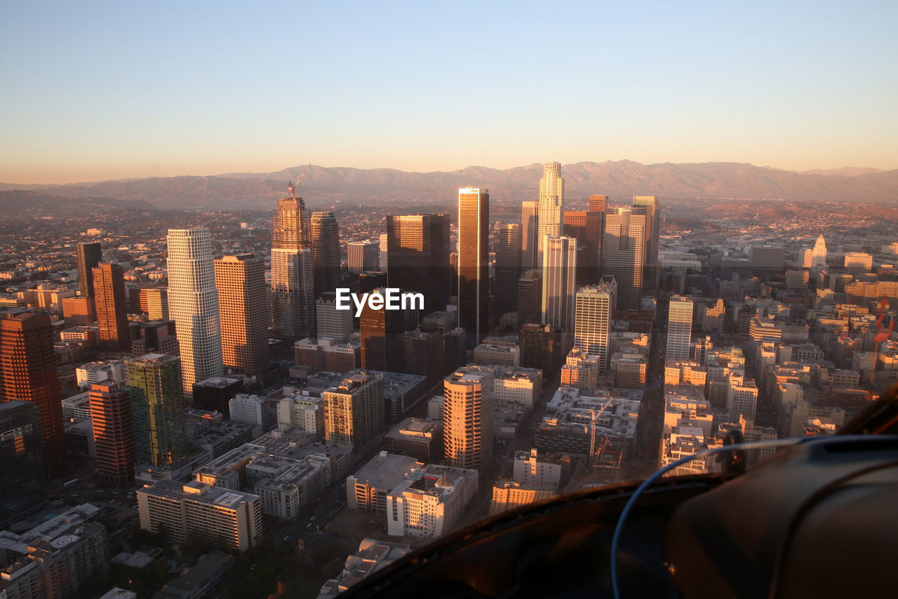 Cityscape against clear sky seen through helicopter